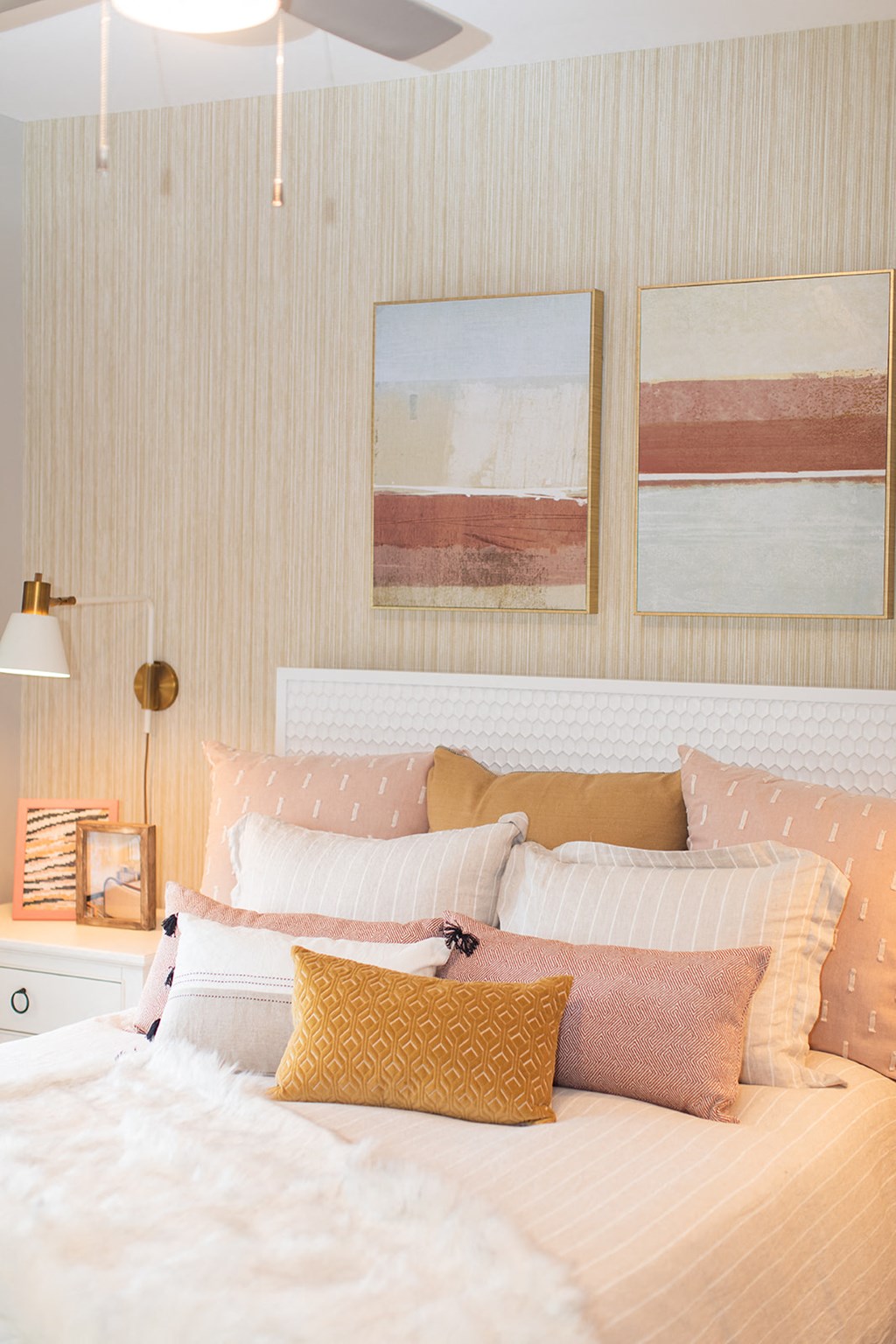 a bedroom with a bed with pillows and pictures on the wall at The Yards at Malvern, Malvern, PA