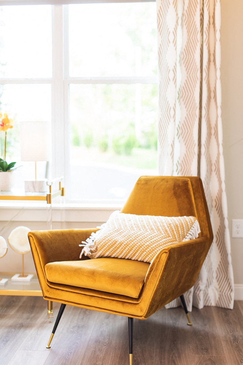 a yellow chair with a pillow in a room with a window at The Yards at Malvern, Malvern, PA
