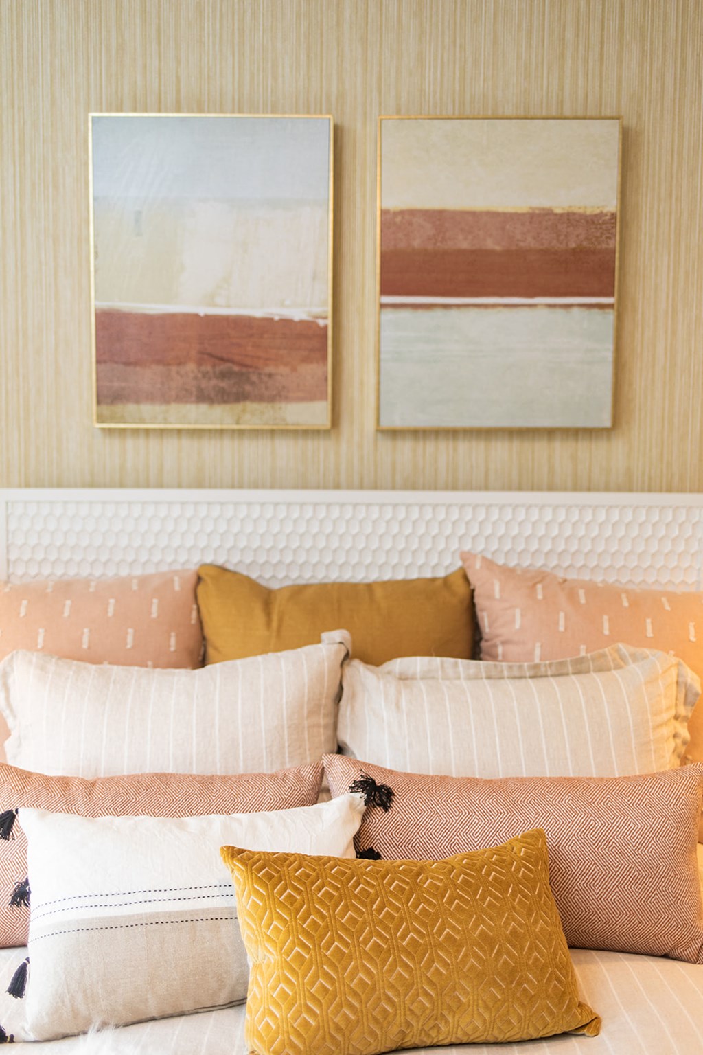 a bedroom with pillows and paintings on the wall at The Yards at Malvern, Malvern, PA