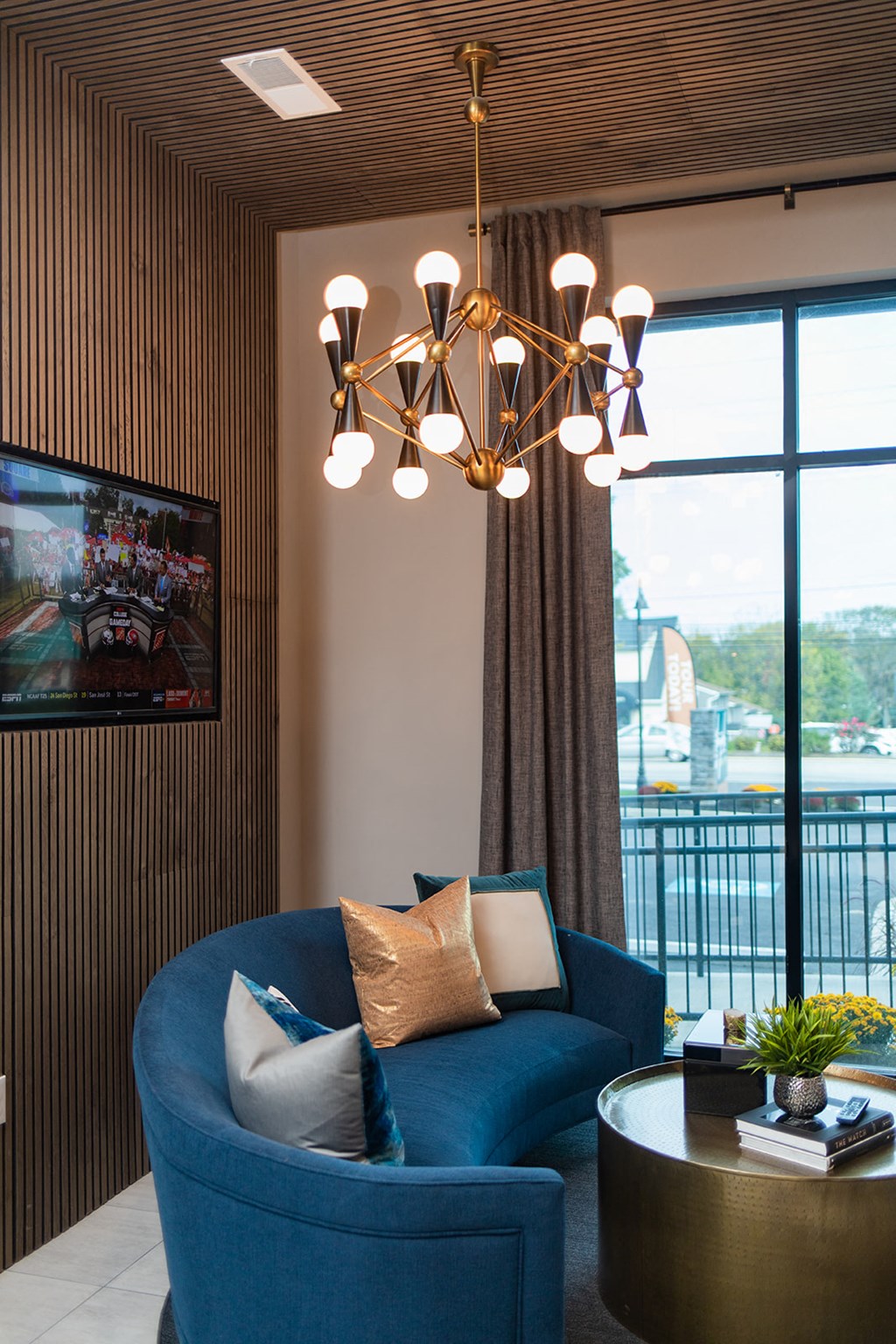 a living room with a blue couch and a chandelier at The Yards at Malvern, Malvern, PA