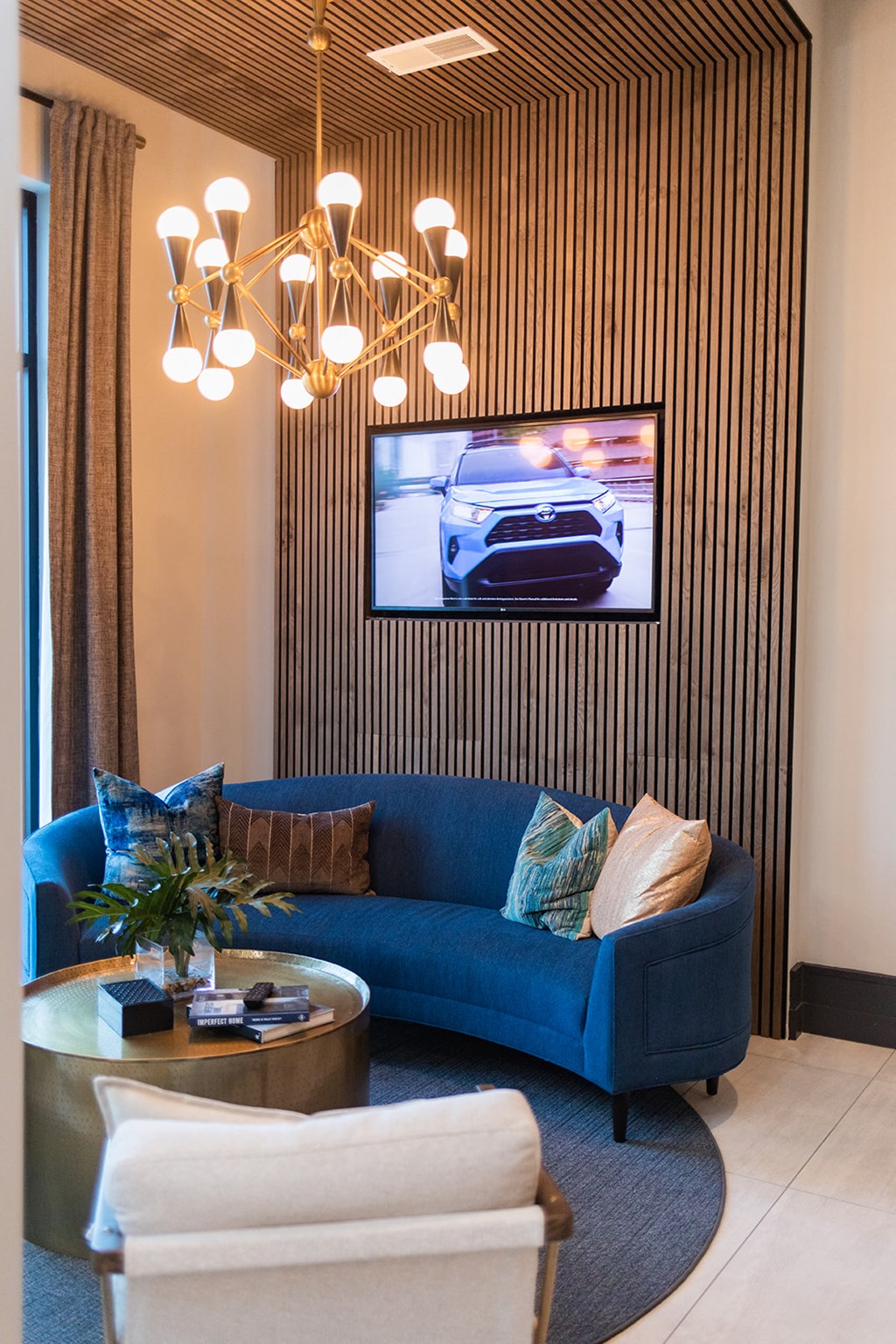 a living room with a blue couch and a television on the wall at The Yards at Malvern, Malvern, PA
