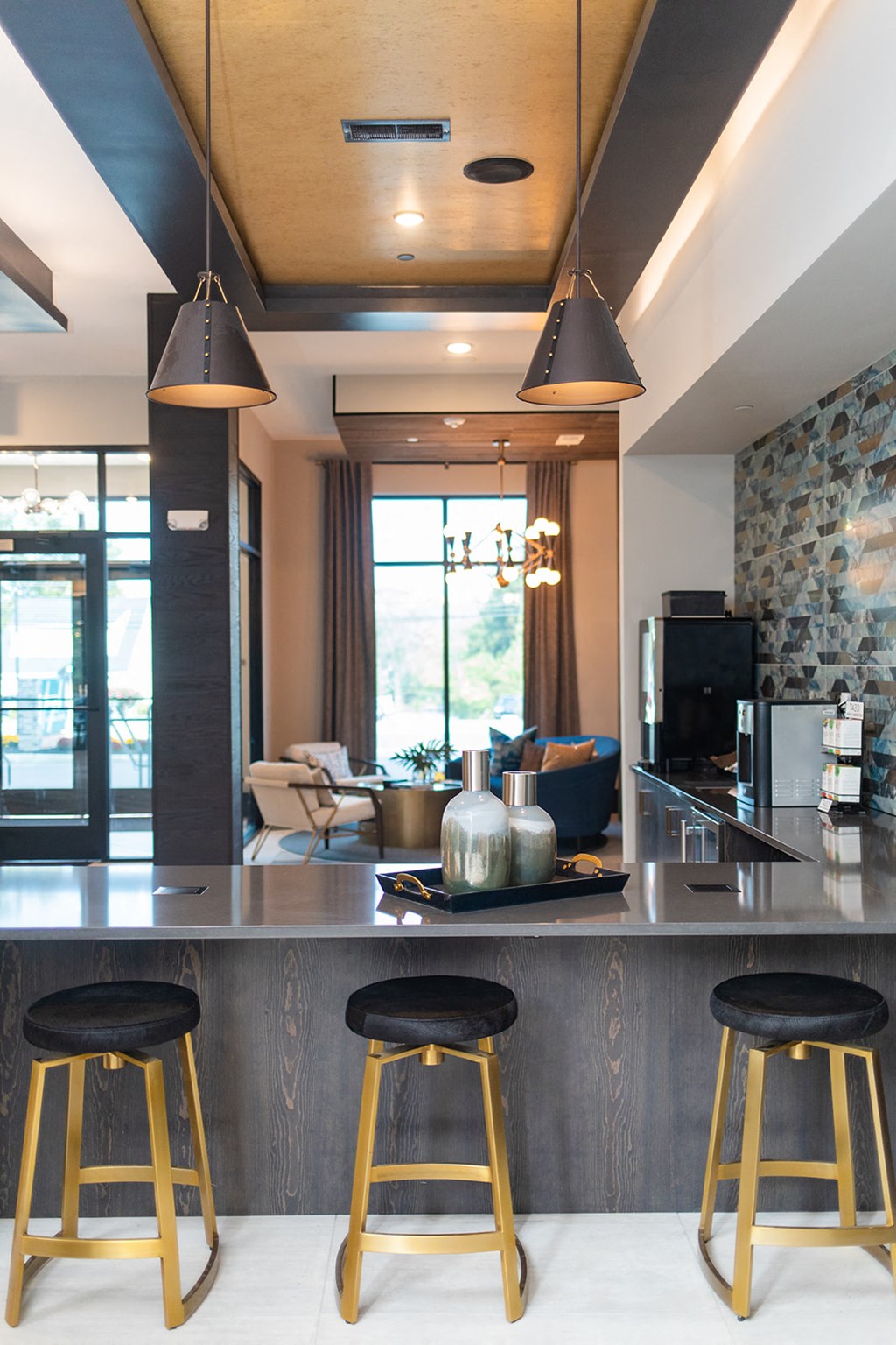 a kitchen with three stools in front of a counter top at The Yards at Malvern, Malvern, PA
