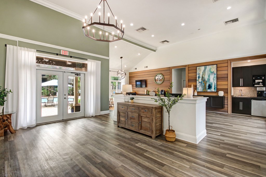A modern kitchen with a wooden floor and a white counter.