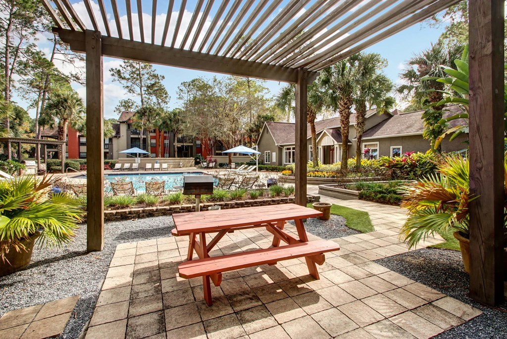 A wooden picnic table is in the middle of a patio.