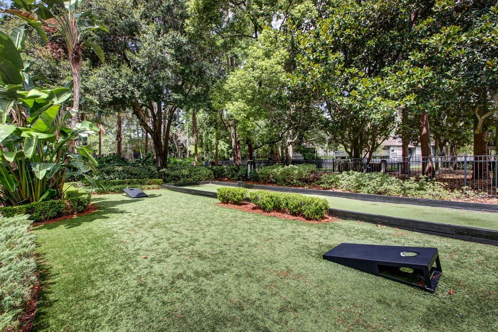 A black object is on the grass in a well kept garden.