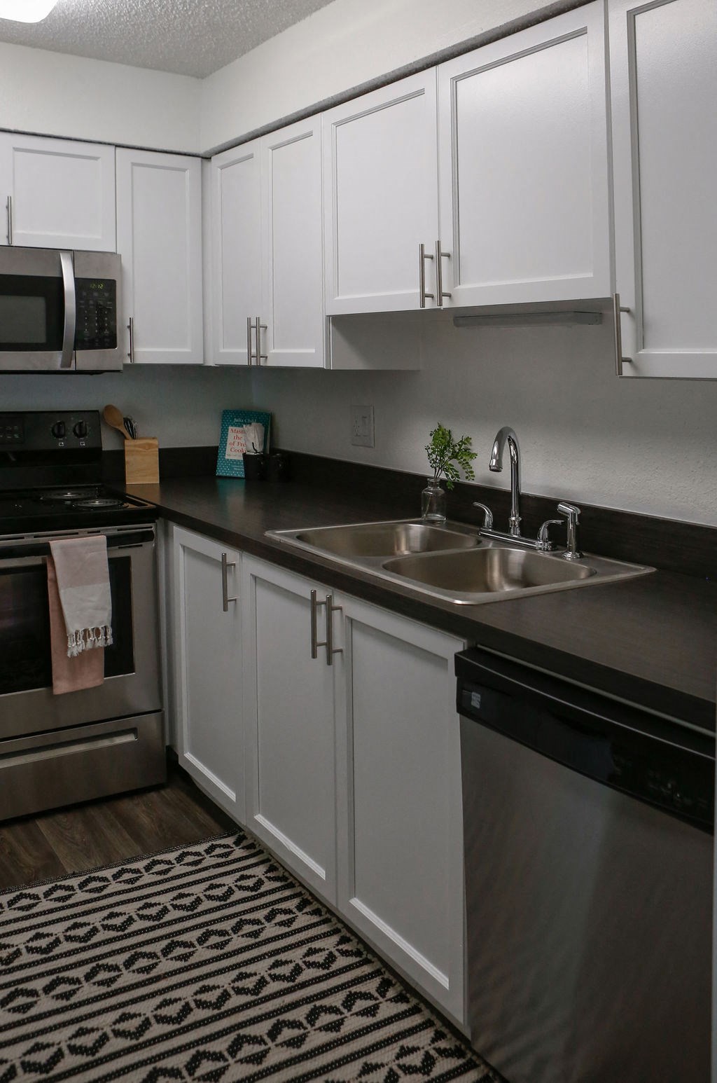 a kitchen with white cabinets and black countertops  at The Villas at Flagler Pointe, Florida, 33712