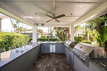 a large outdoor kitchen with stainless steel appliances and a ceiling fan at Champions Walk Apartment Homes, Bradenton, Florida