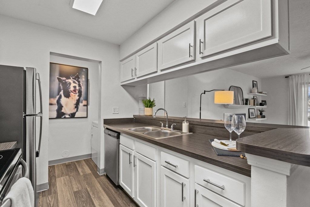 A modern kitchen with white cabinets and a wooden countertop.