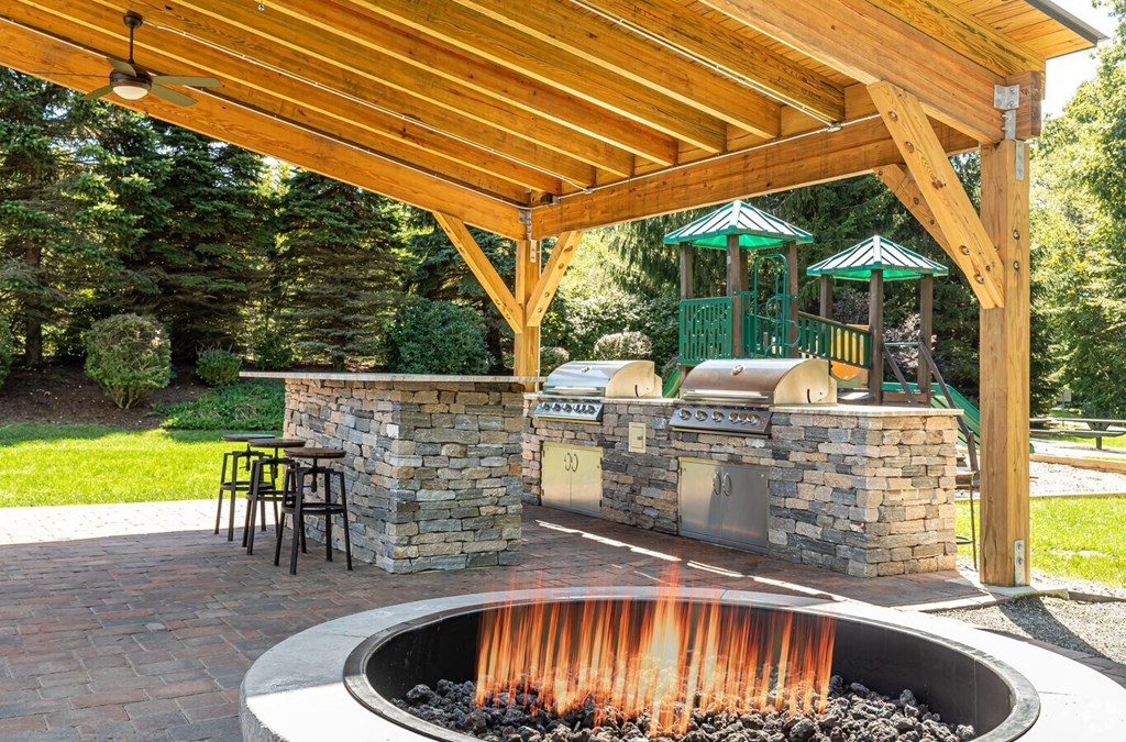 a backyard with a barbecue grill and a fire pit at The Ledges Apartment Homes, Connecticut