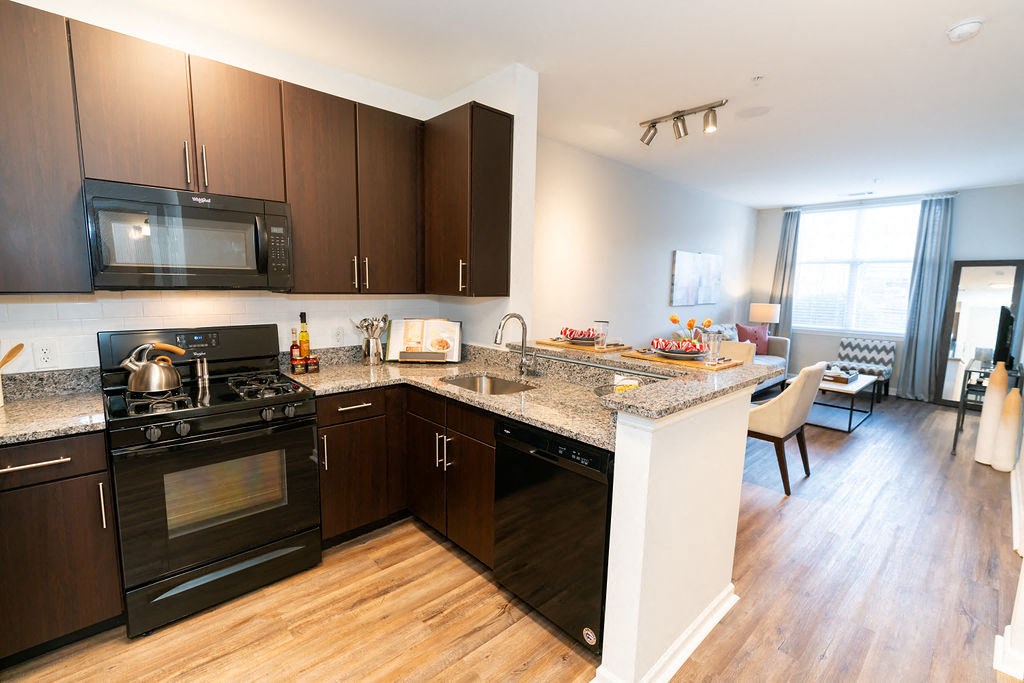 a kitchen with black appliances and granite counter tops  at Merion Riverwalk Apartment Homes, Shelton, 06484