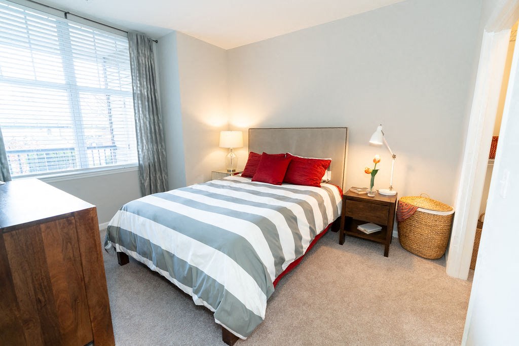 a bedroom with a bed and a large window at Merion Riverwalk Apartment Homes, Connecticut, 06484