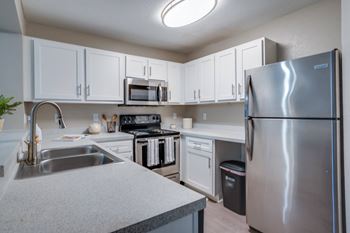 a kitchen with stainless steel appliances and white cabinets at The Monroe Apartment Homes, Tallahassee, 32303