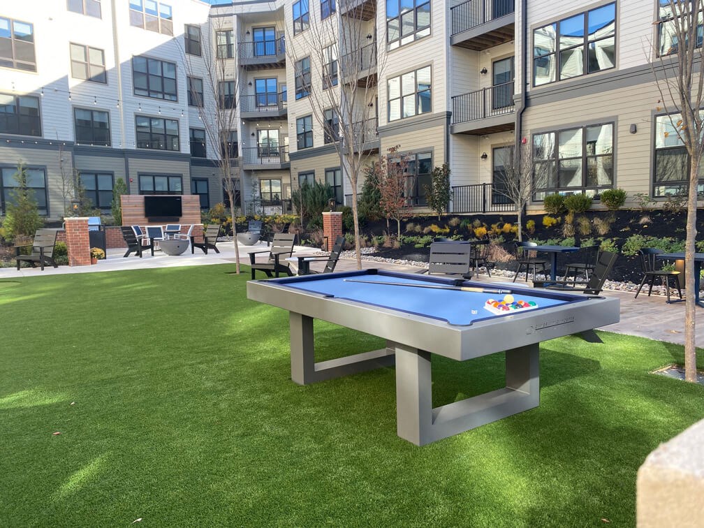a ping pong table in a courtyard with an apartment building at The Yards at Malvern, Malvern