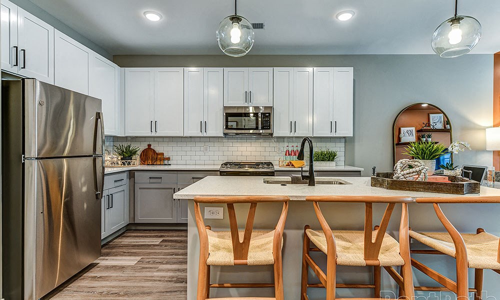 a kitchen with white cabinets and a wooden table at The Yards at Malvern, Malvern, 19355