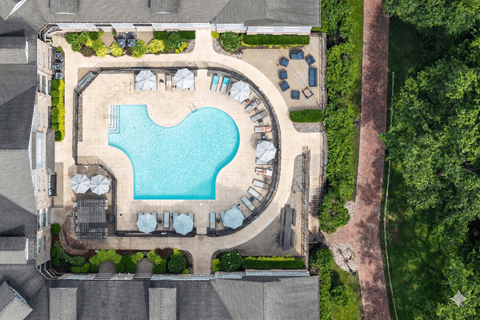 A large swimming pool surrounded by lounge chairs and umbrellas.