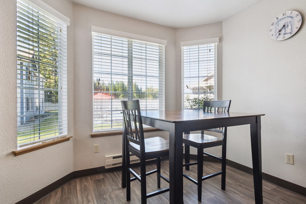 a dining room with a table and chairs and windows