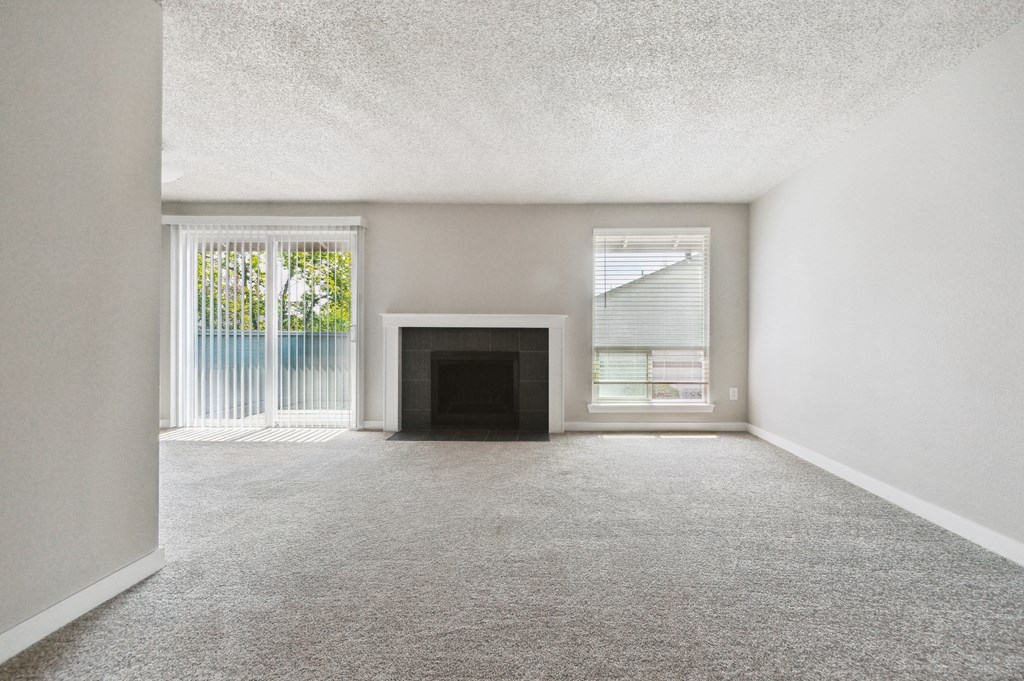 an empty living room with a fireplace