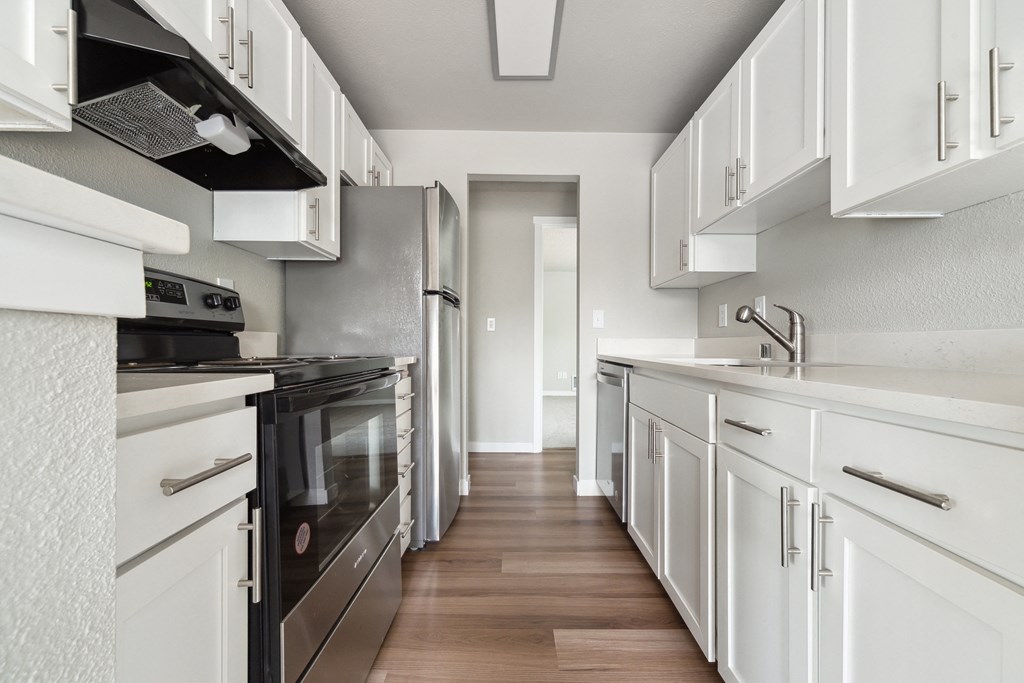 a kitchen with white cabinets and stainless steel appliances