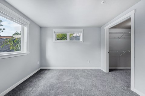 an empty room with a closet and a window