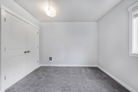 an empty room with white walls and carpet and white doors