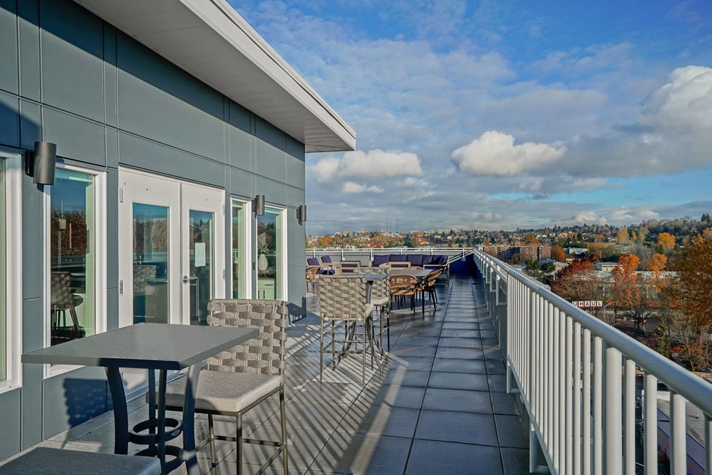 a balcony with tables and chairs and a view of the city