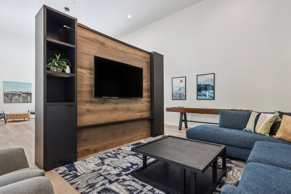 a living room with a blue couch and a television