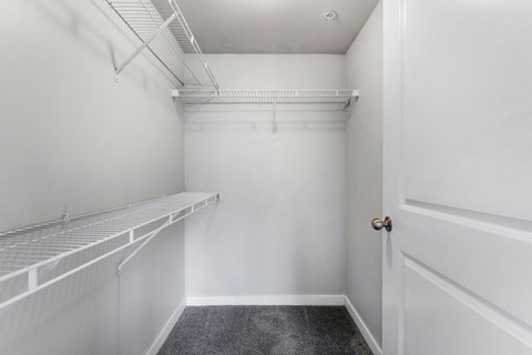 an empty closet with white walls and a white door