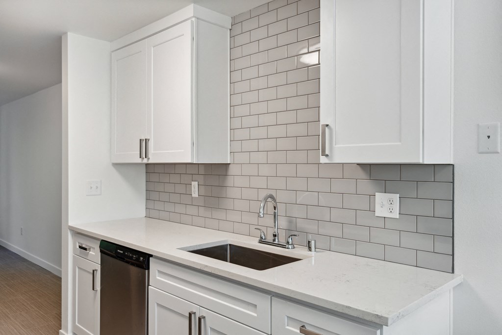 a kitchen with white cabinets and a sink