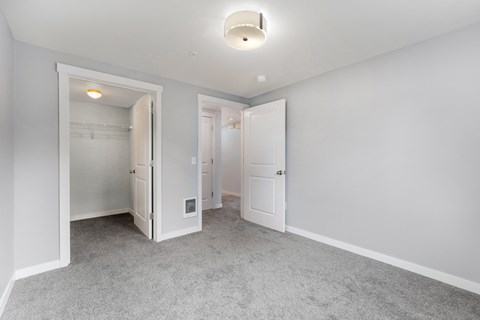 a bedroom with white walls and white doors and a carpeted floor