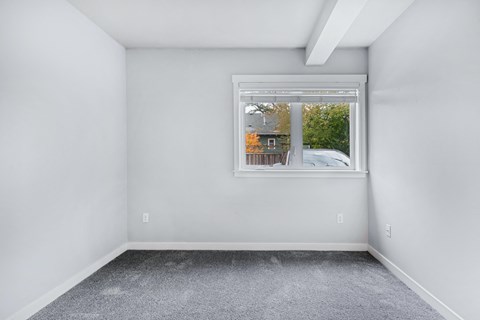 an empty room with white walls and a window