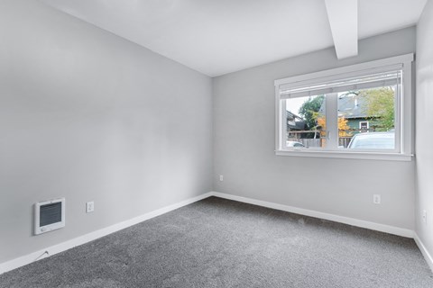 an empty room with carpet and a window