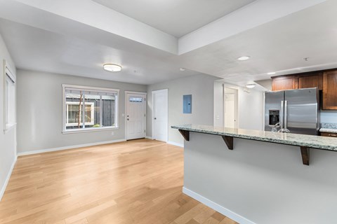 a renovated living room with a kitchen and a large window