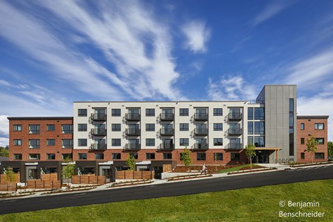 A modern apartment building with a mix of brick and glass exterior.