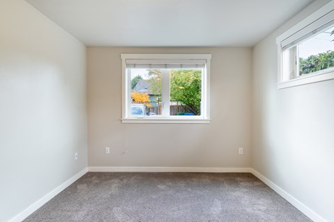 an empty room with a window and carpet