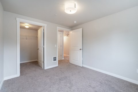 a bedroom with white walls and white doors and carpeting