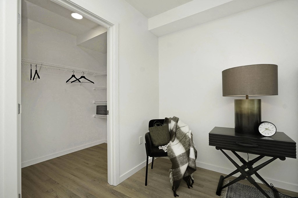 a living room with a chair and a lamp and a closet