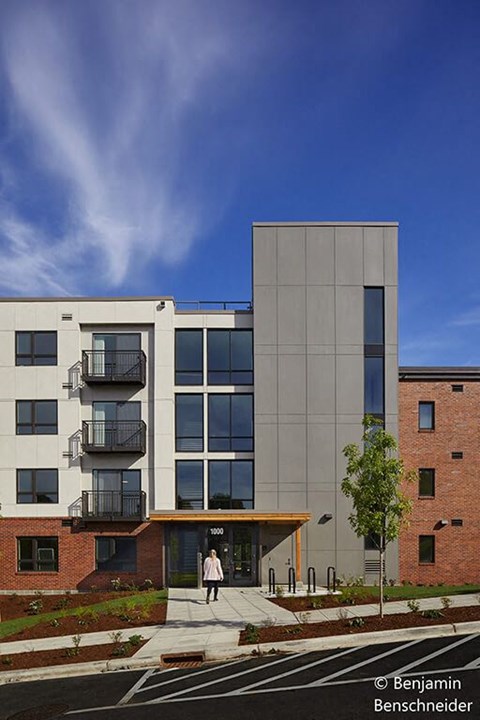 A modern building with a woman walking in front.