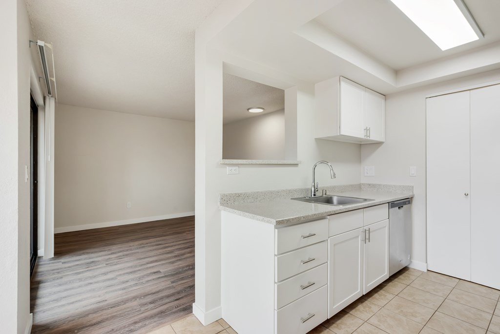 A kitchen with white cabinets and a sink.