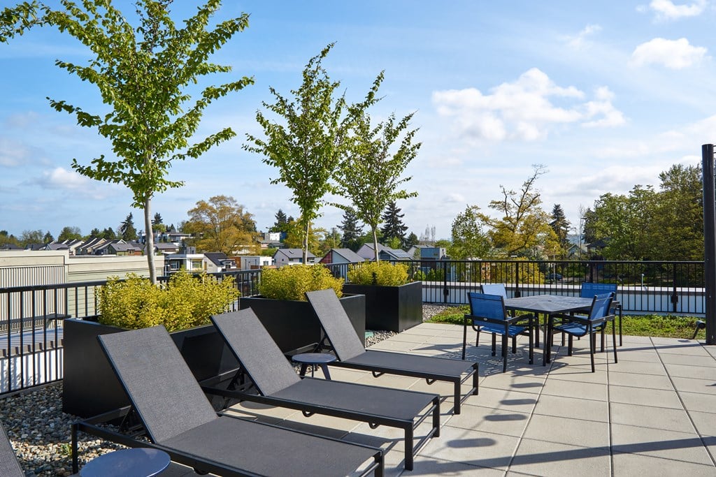 a patio with tables and chairs on a rooftop