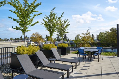 a patio with tables and chairs on a rooftop