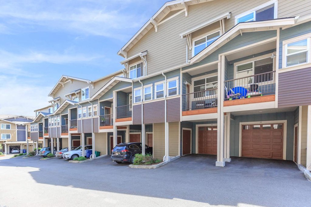 a row of houses with cars parked in front of them