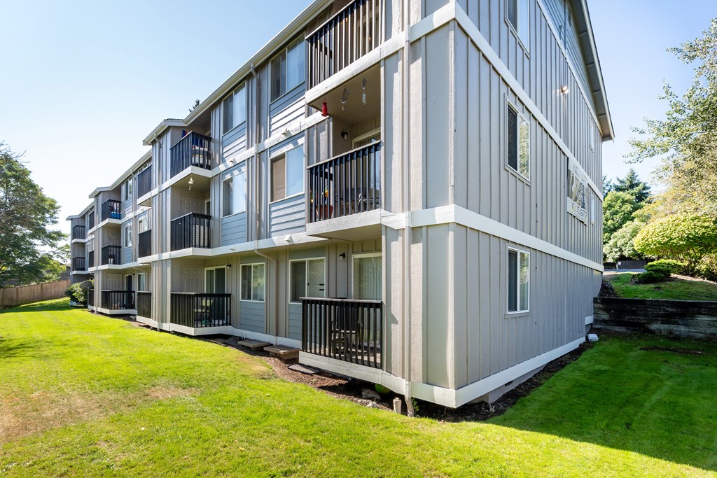 A large, modern apartment building with balconies and multiple windows.