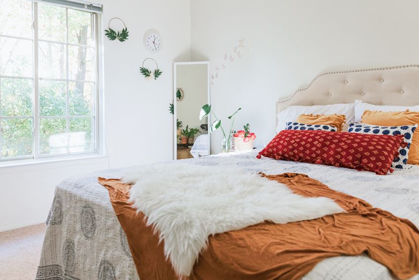 a bedroom with a bed and pillows and a window
