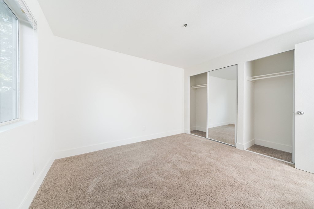 a room with carpet and white walls and sliding glass doors