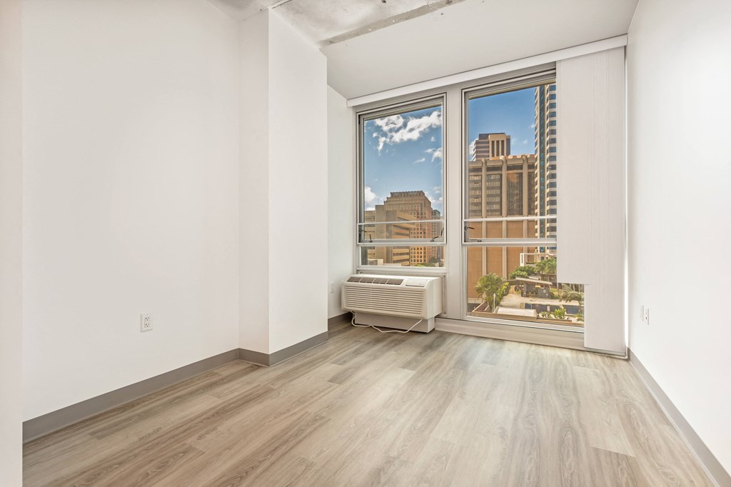 a living room with a large window and wooden floors