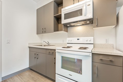 an empty kitchen with white appliances and stainless steel cabinets