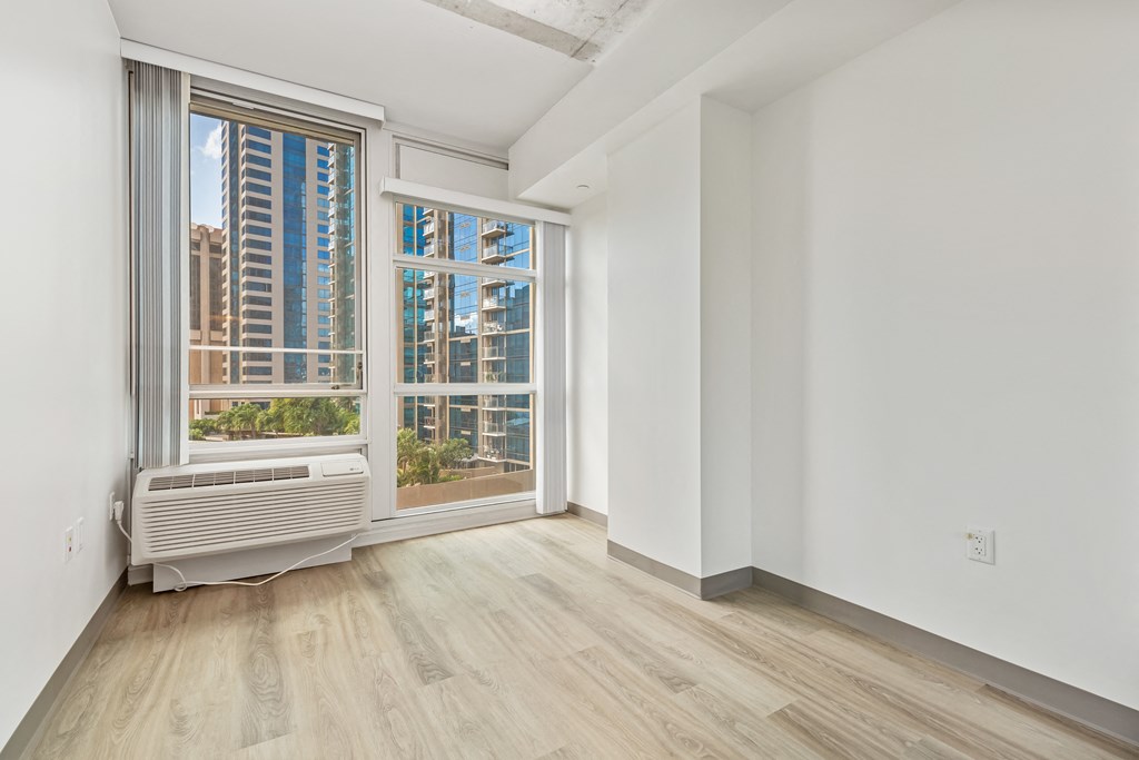 a living room with a large window and a radiator on the floor
