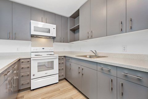 a kitchen with white appliances and gray cabinets