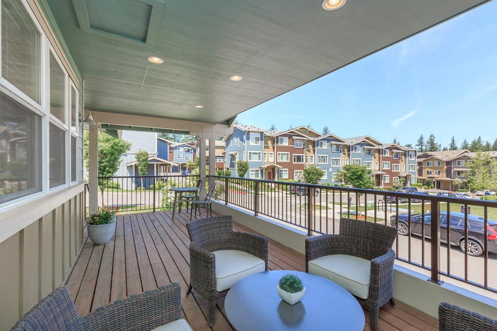 a balcony with two wicker chairs and a table