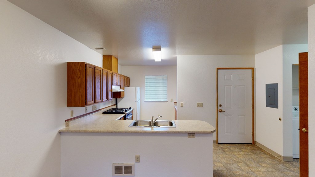 a kitchen with a sink and a door to a living room